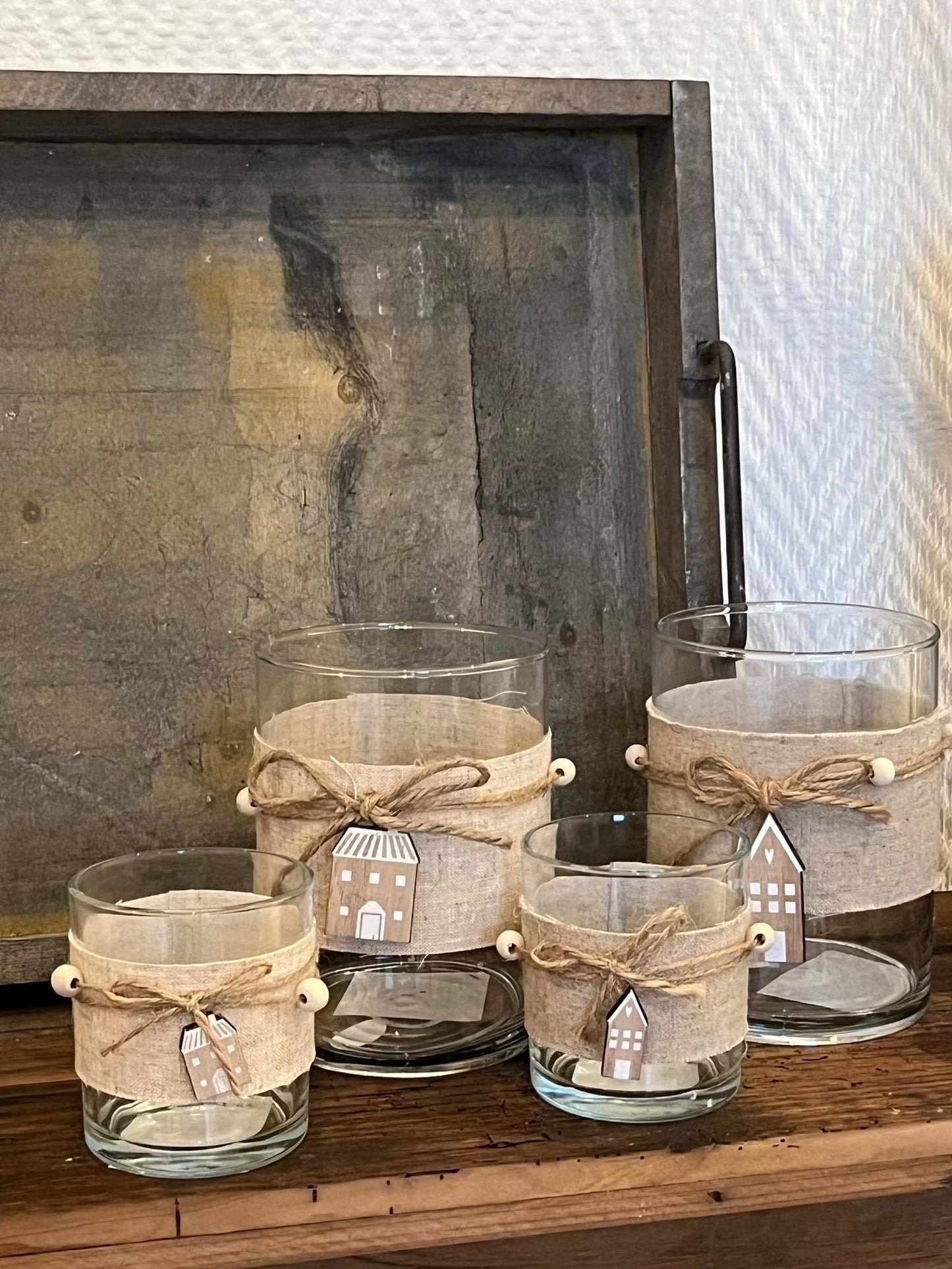 Windlicht Nordy glass candle holders with linen band and wooden house decorations in two sizes.