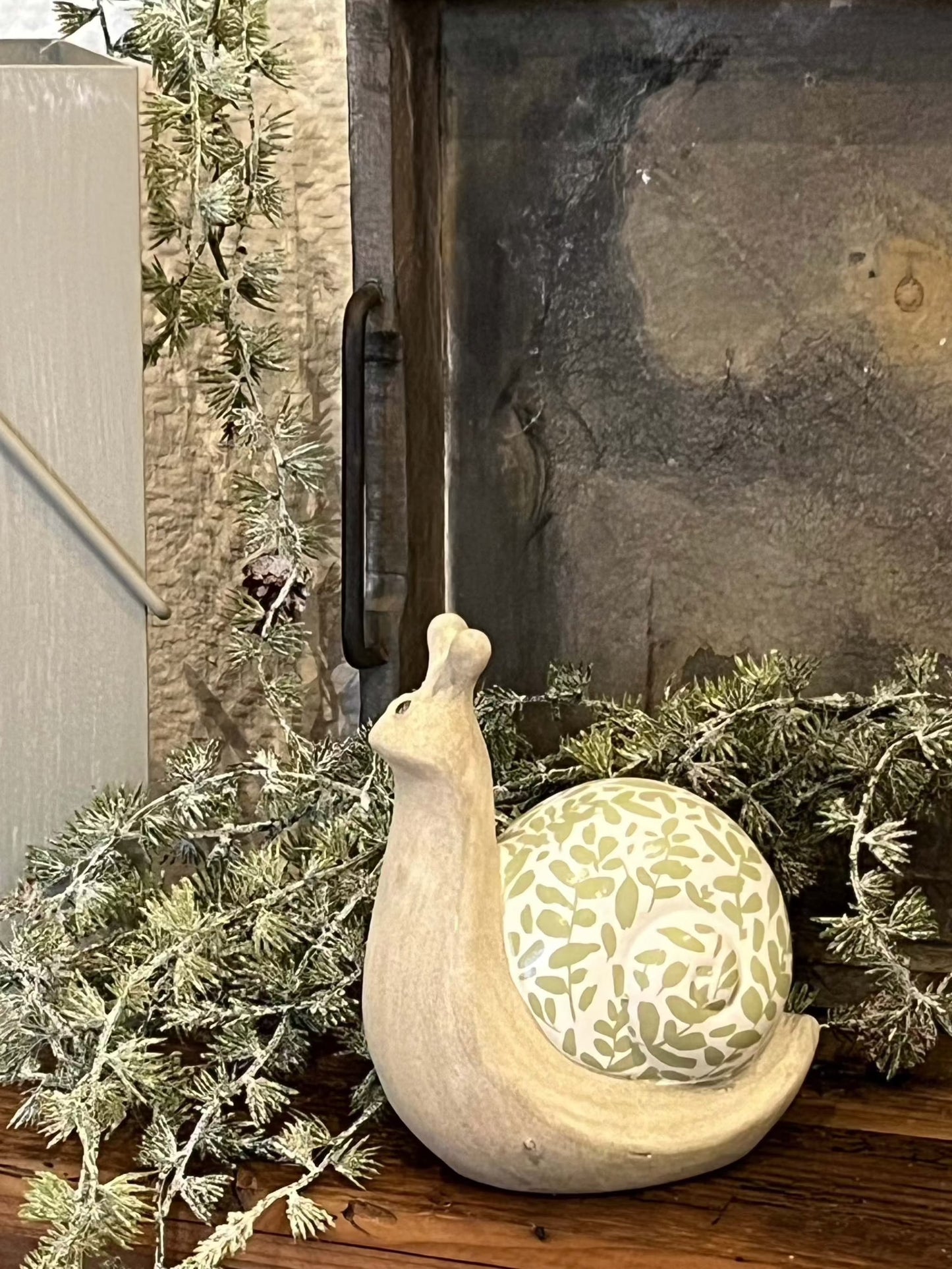 Ceramic snail decoration in green and light green, adds a playful touch to your decor.